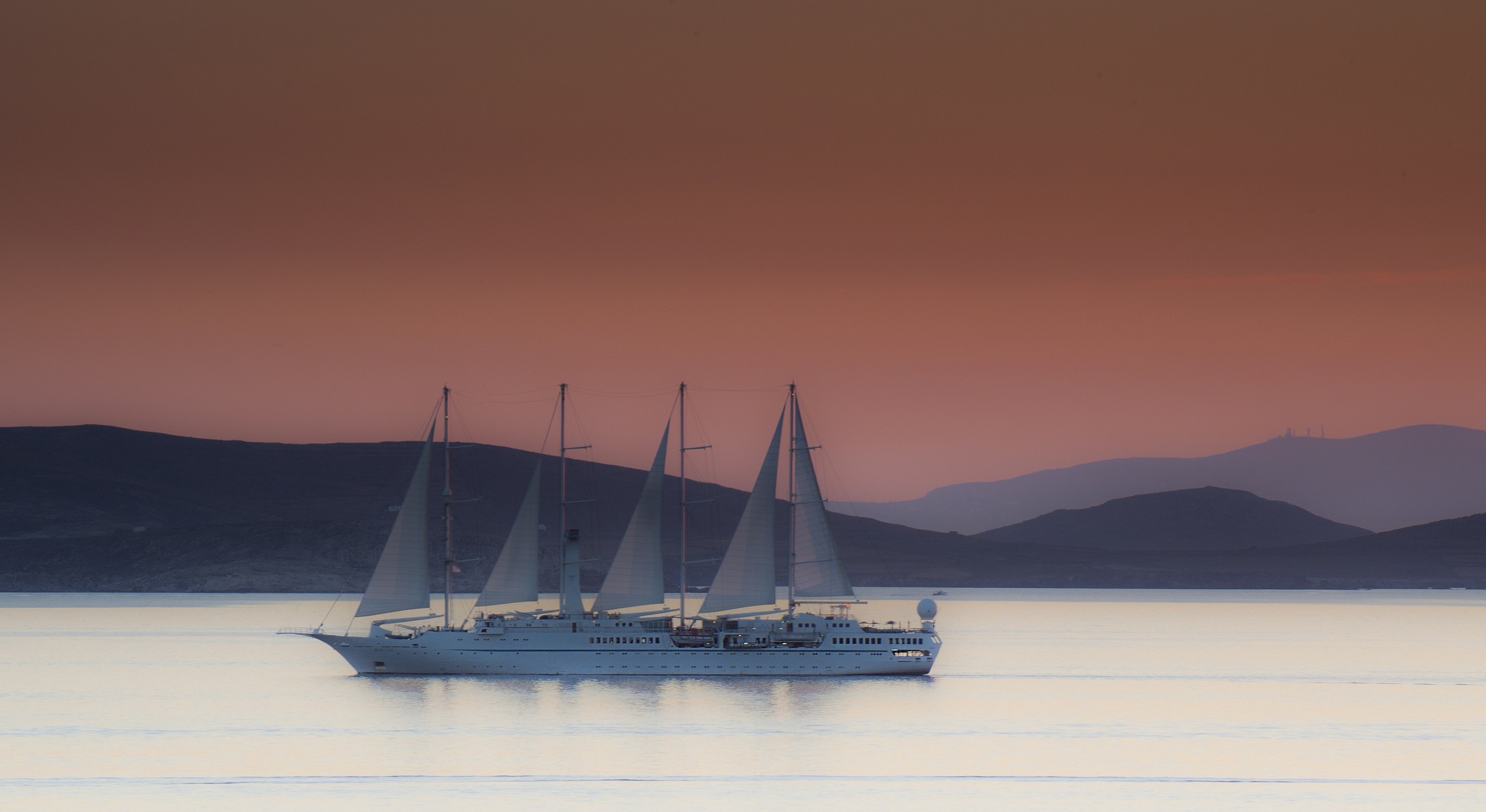 Sailing ship at sunset in the background of the island