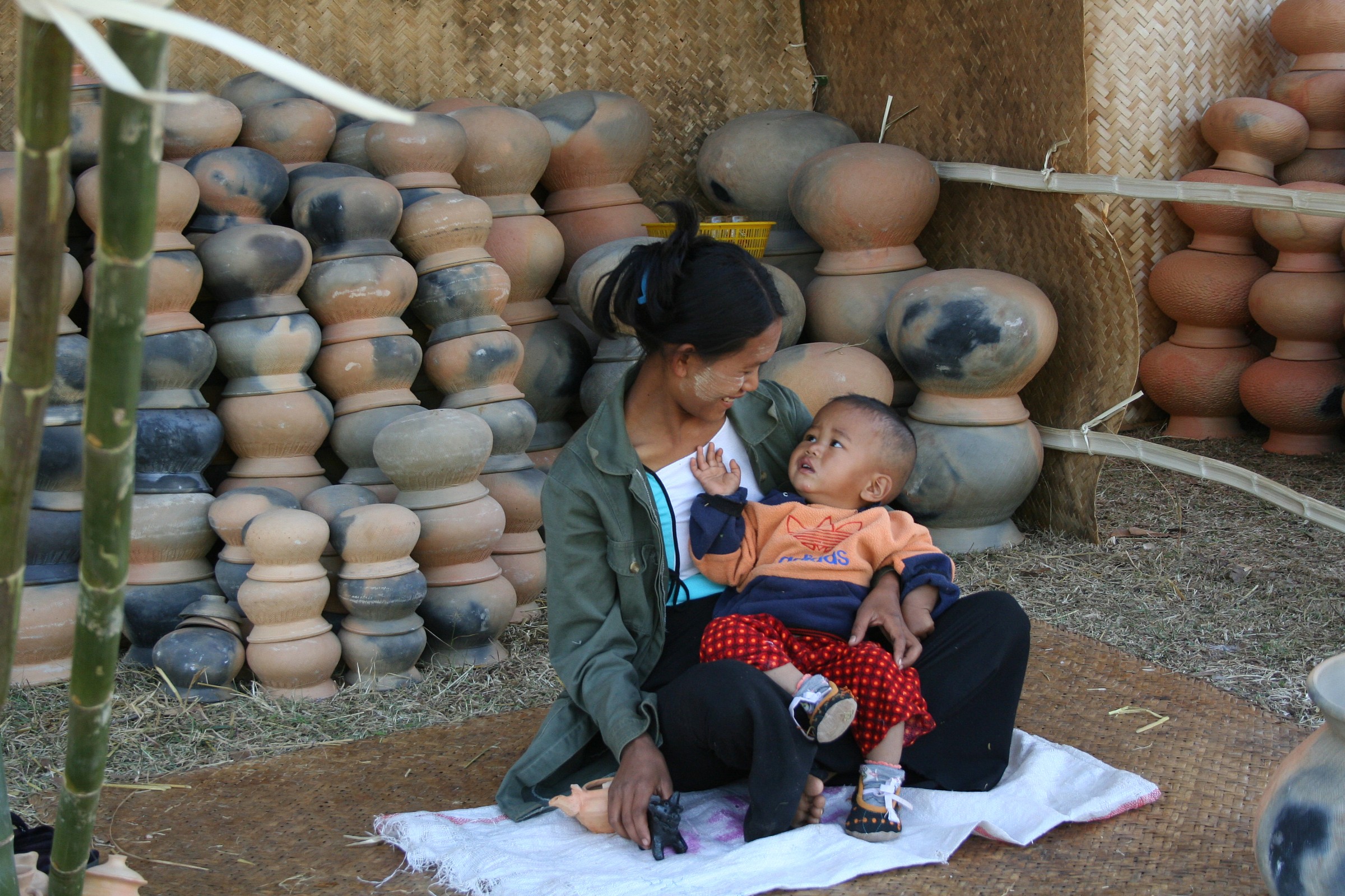 Myanmar venditrice di vasi coccola il suo piccolo