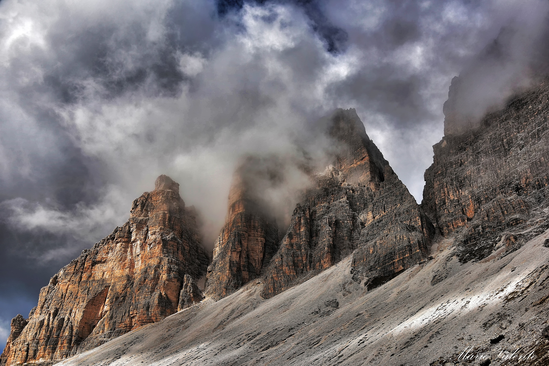 Le Tre cime spuntano tra le nubi ed i raggi di luce