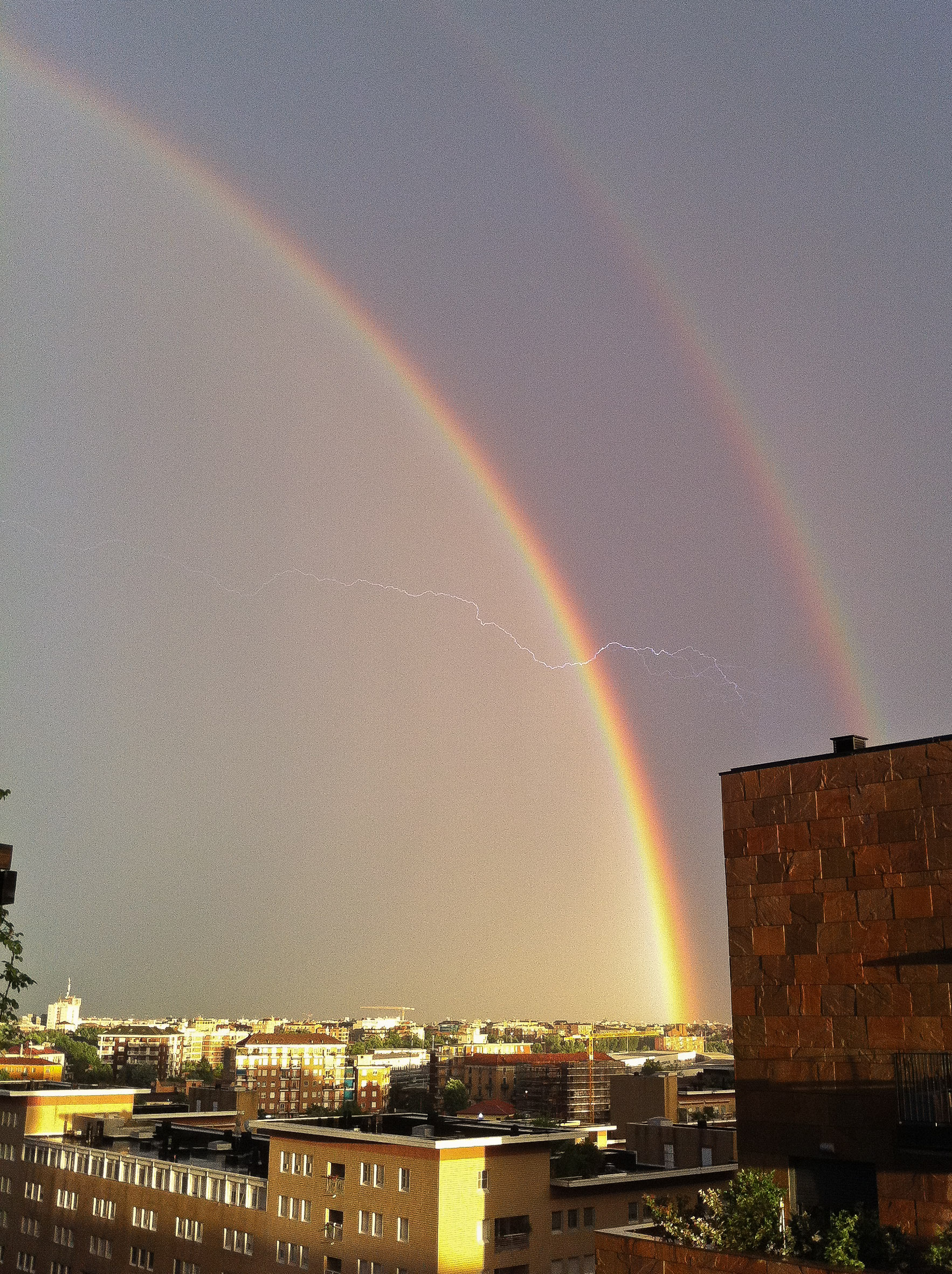 Doppio arcobaleno con fulmine a Milano