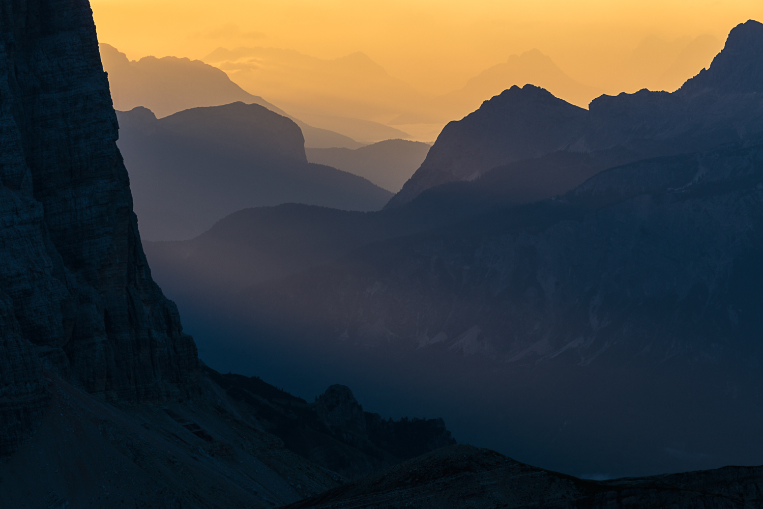 The sun rises behind the Tofane