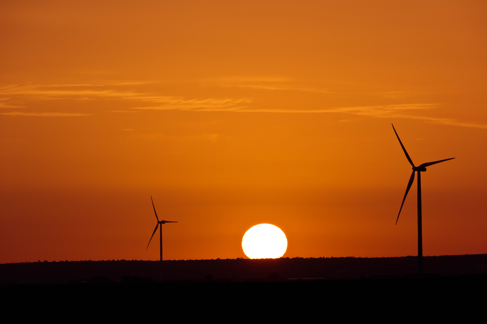 Sunset between the wind turbine blades