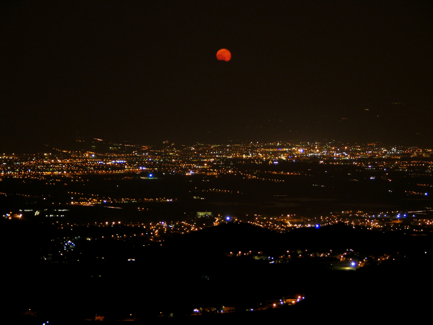 Luna rossa sopra la zona fra Firenze e Prato