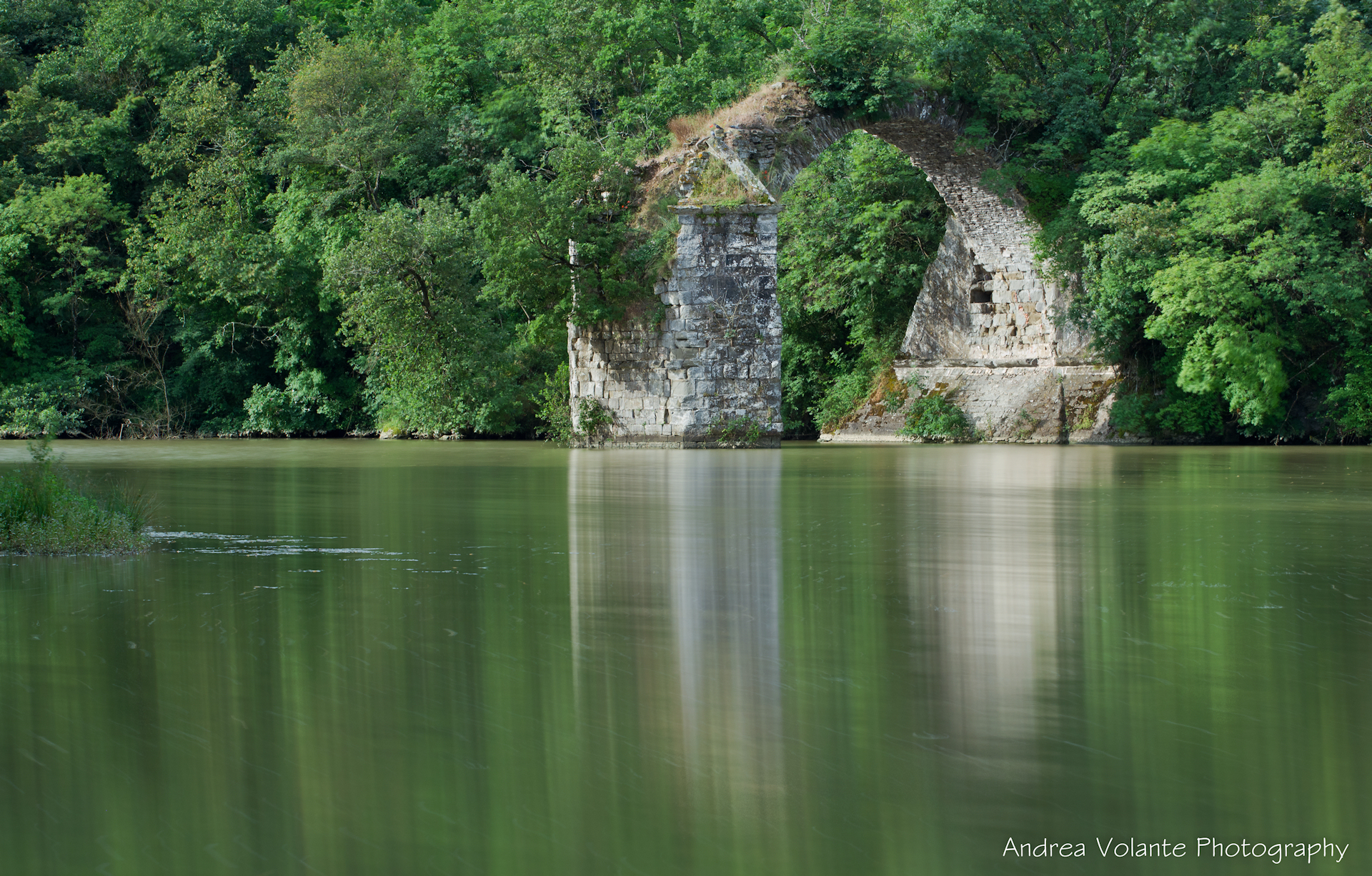 Among the placid waters of the Arno the remains of the bridg...
