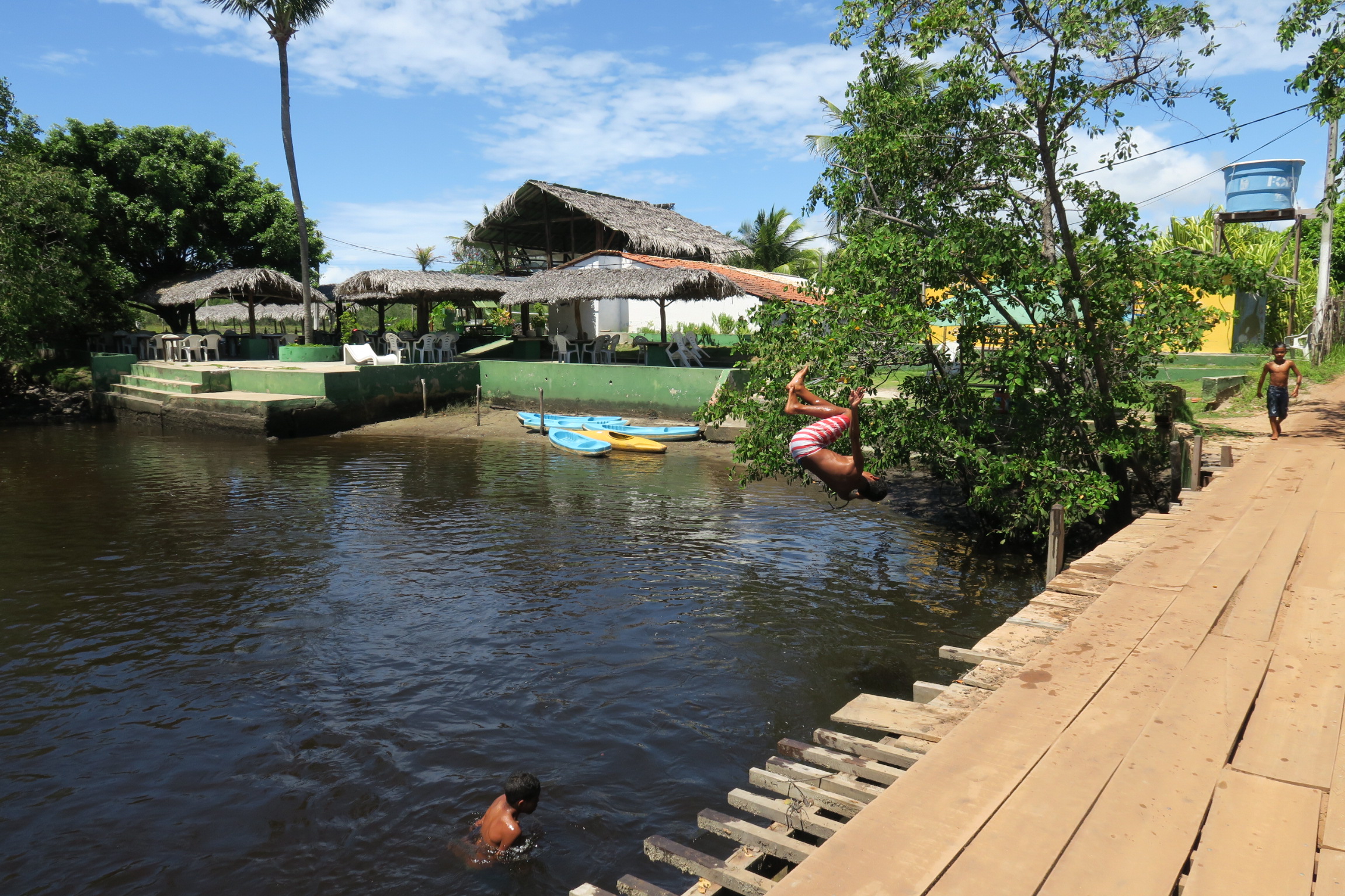 Bimbi brasiliani che si tuffano con acrobazie nel fiume