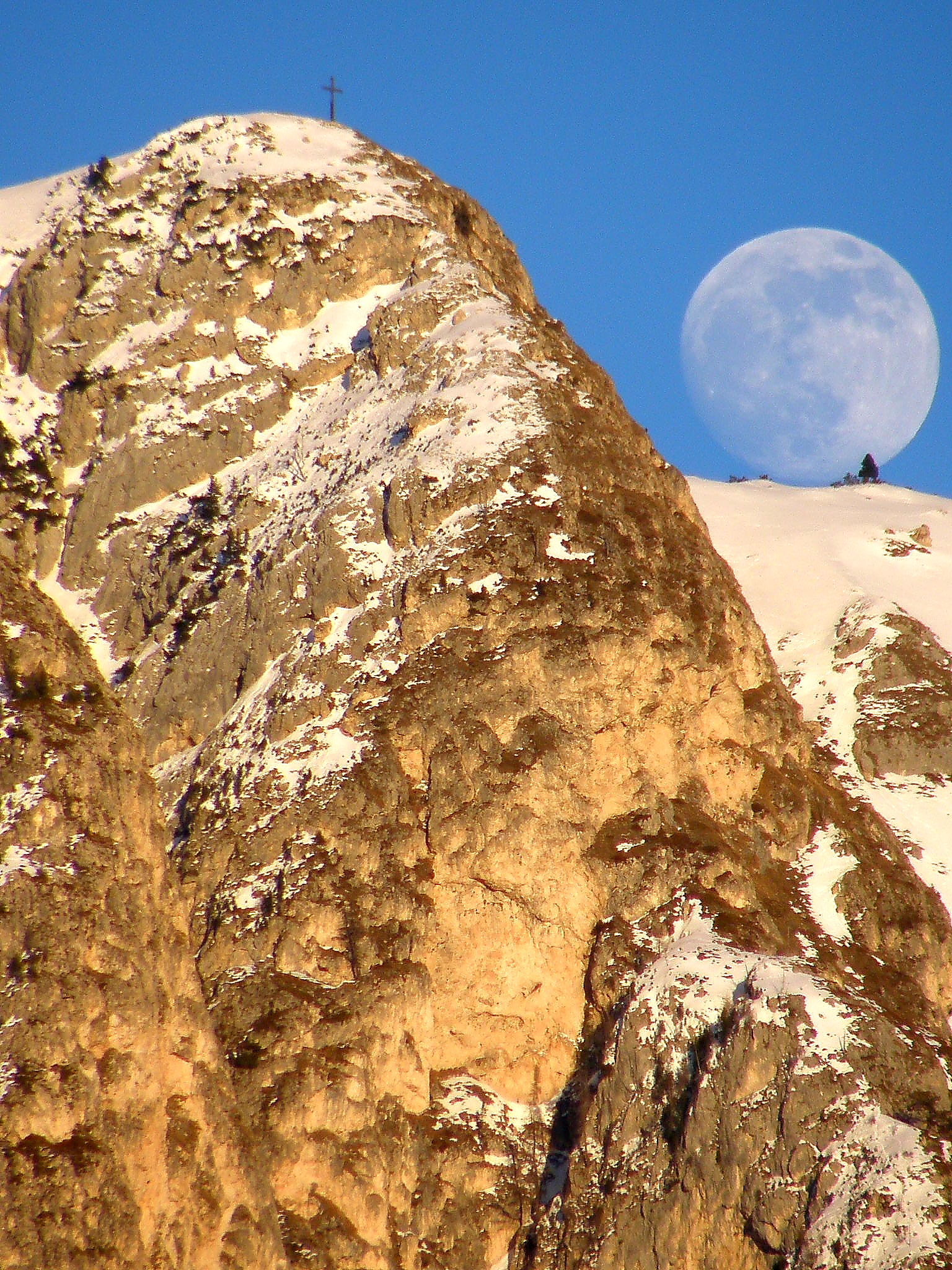 Luna piena sbuca dal monte Cornon