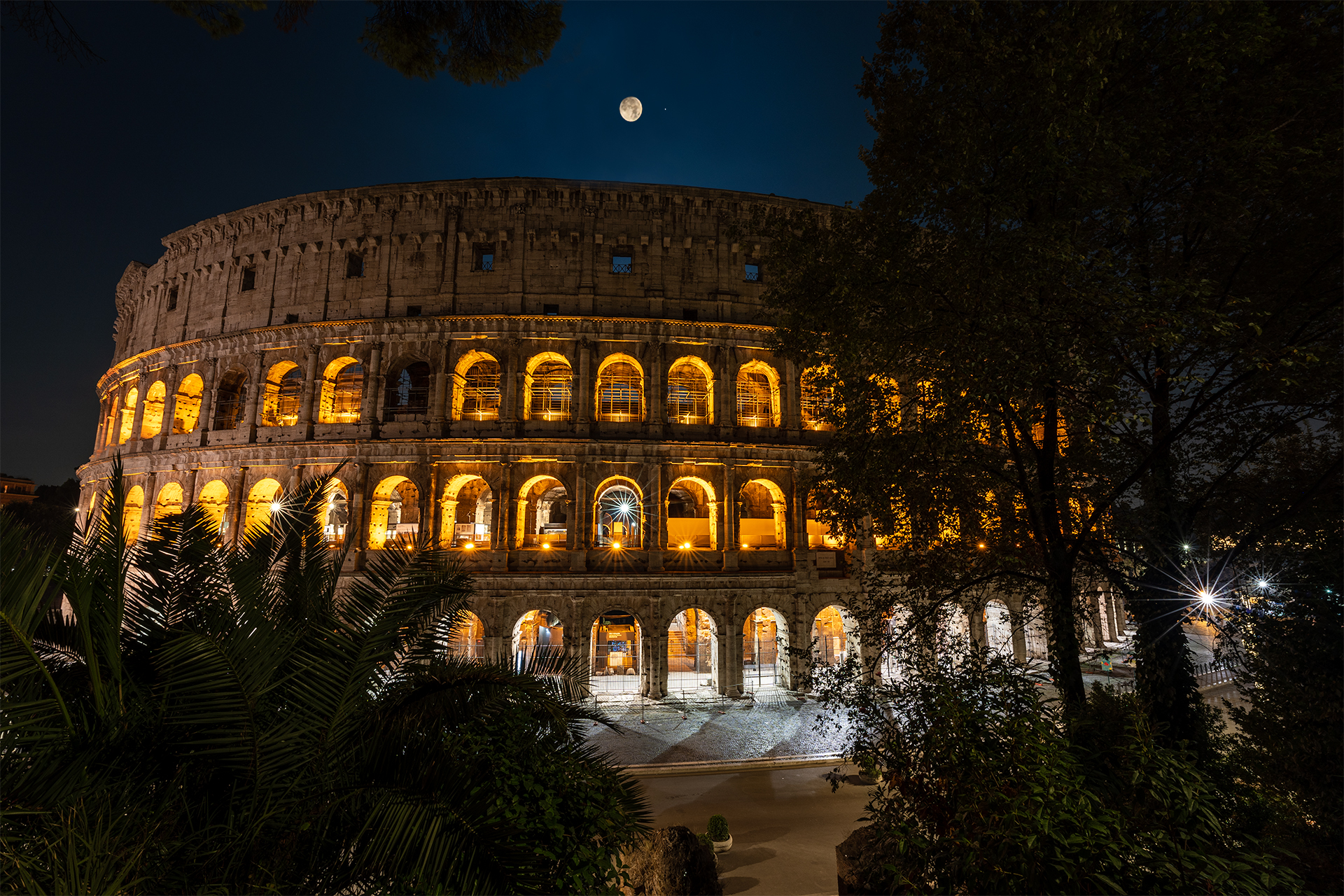 The moon rises over the Colosseum