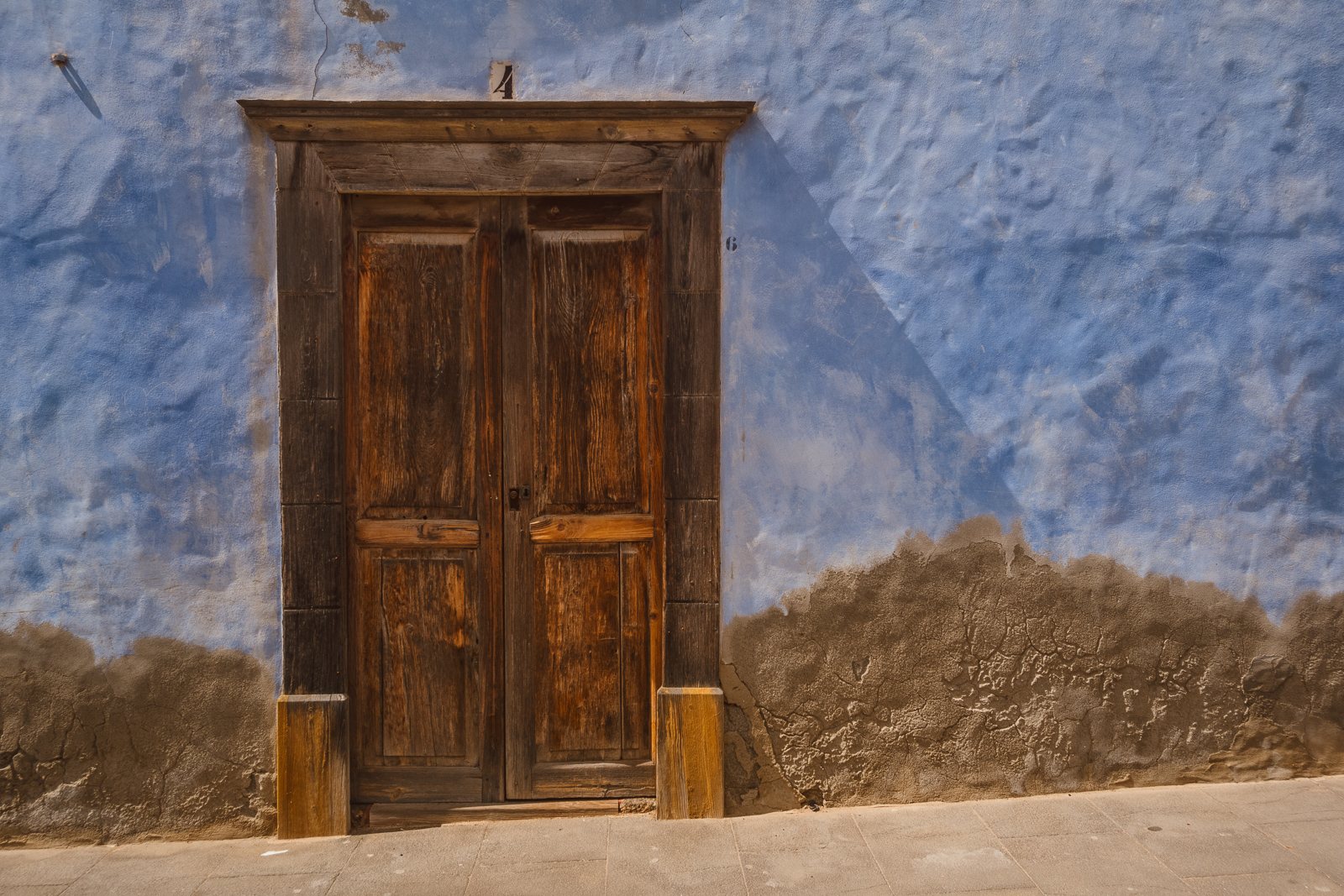 Puerta antigua en pared celeste.