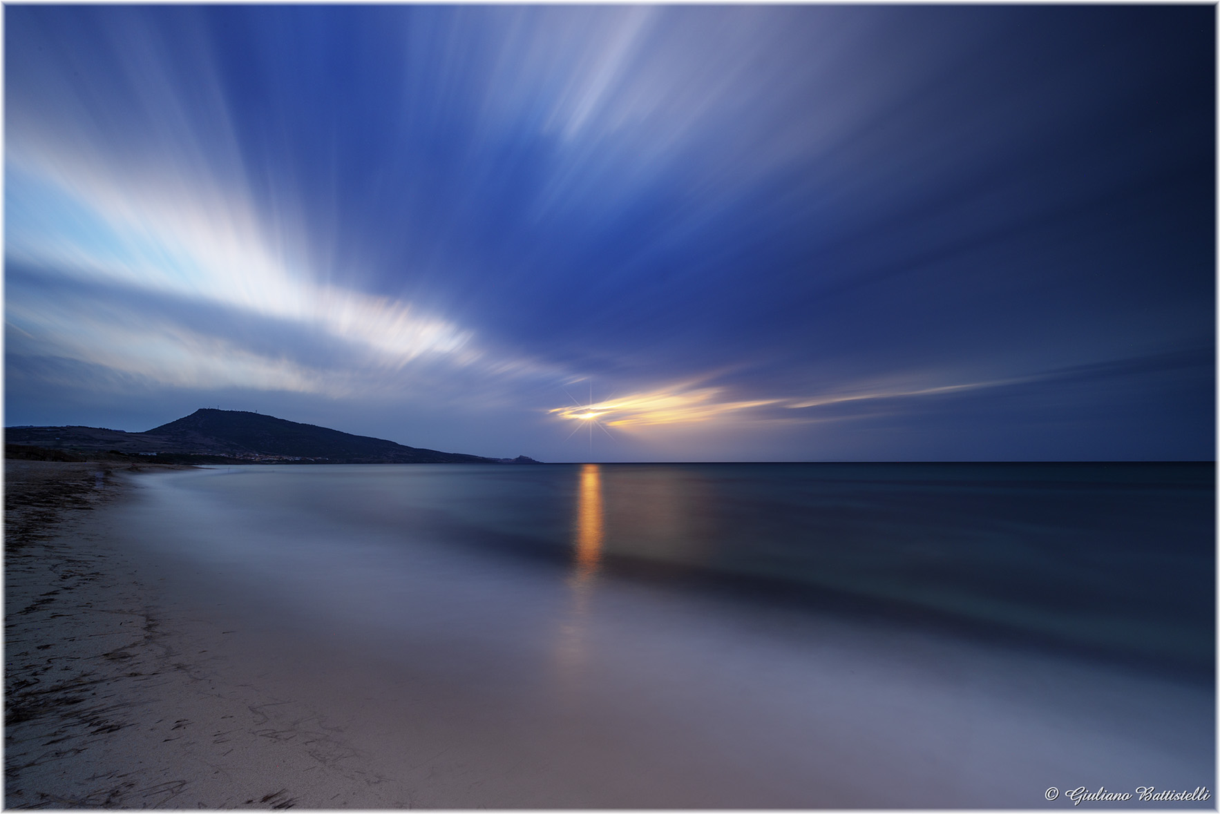 Strisce di luce, con riflessi sul mare.