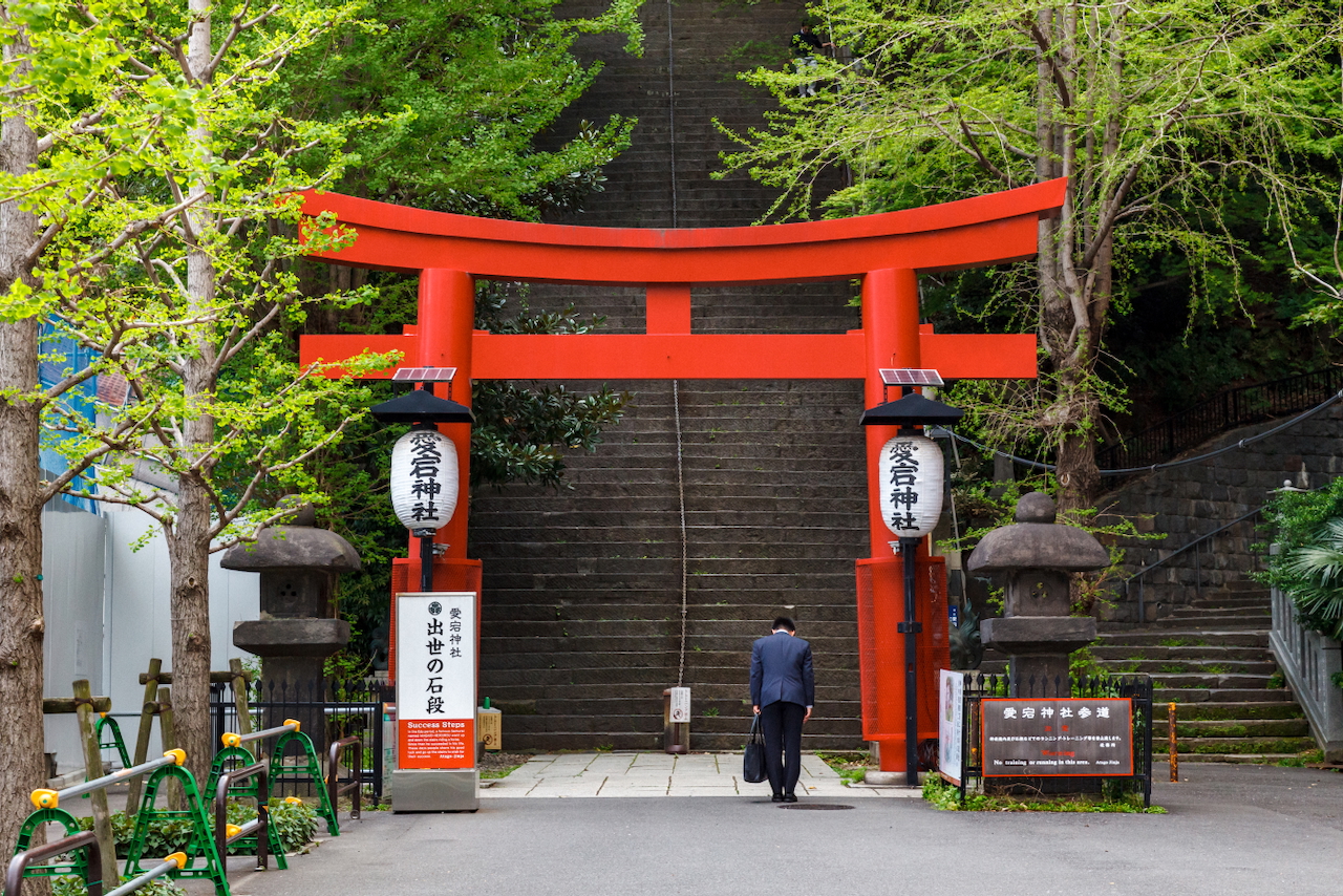 Man bows under the entrance of a temple