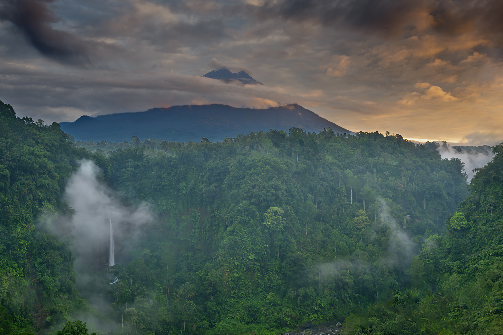 Kapas Biru Waterfall with Semuro Volcano at sunrise