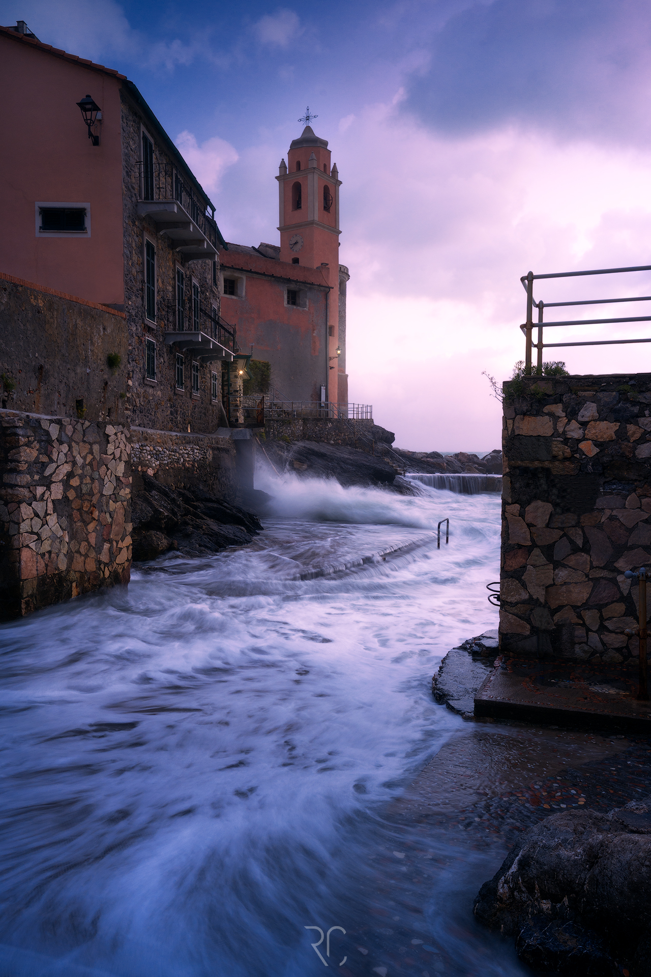 Rocks, waves and a bell tower on the sea