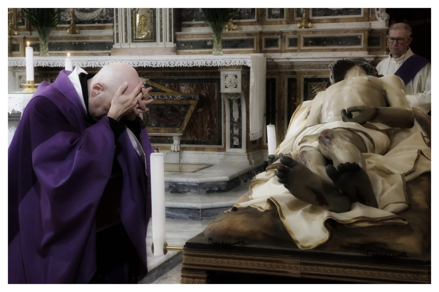 Priest praying before the Dead Christ